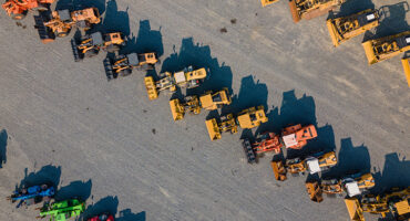 An aerial view of perfect rows of wheel loaders and other heavy machinery