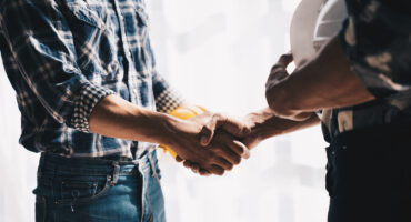 Businessman handshake with engineering in construction renovate building site. Engineer/architect inspection workplace for project.Teamwork construction engineer,business and architecture concept.